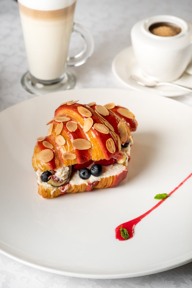 Sweet croissant sandwich with berries while working remotely